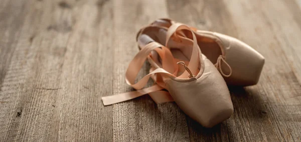 Pointe schoenen met linten op houten ondergrond — Stockfoto