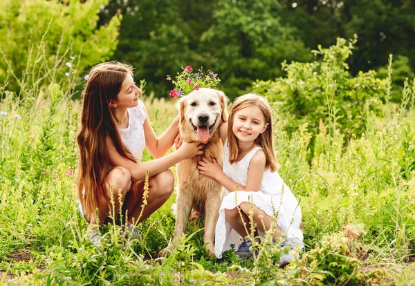 Meninas bonitas brincando com o cão bonito — Fotografia de Stock