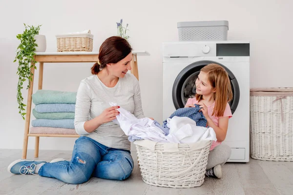 Madre con hija clasificando la ropa después de lavar — Foto de Stock