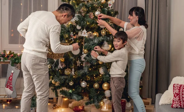 Feliz familia decorando el árbol de Navidad juntos —  Fotos de Stock