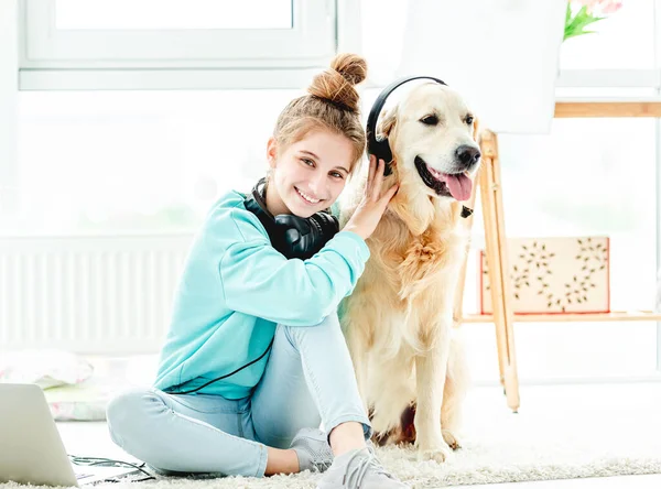 Счастливая девушка с собакой в наушниках — стоковое фото