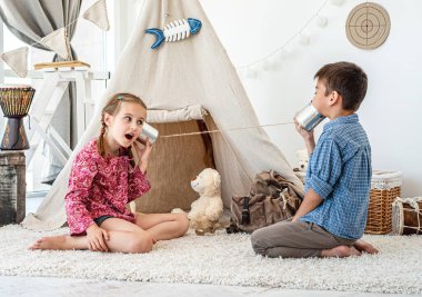 Çocuklar kendi yaptıkları telefonlarla oynuyorlar.