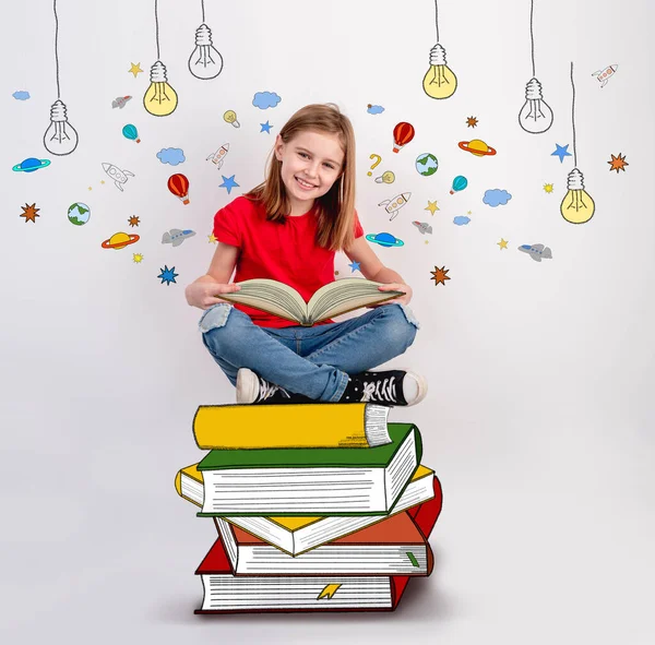 Sorrindo menina lendo livro desenhado — Fotografia de Stock