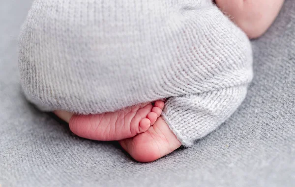 Nackte Füße von Neugeborenen im Anzug — Stockfoto