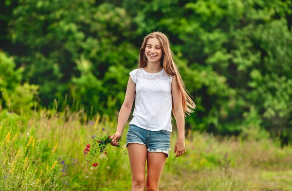 Leende flicka med fält blommor bukett — Stockfoto