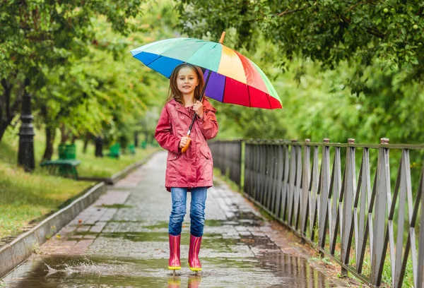 Liten flicka hoppar i pöl — Stockfoto