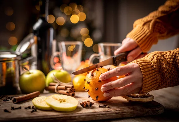 Mujer cortando naranja para vino caliente —  Fotos de Stock