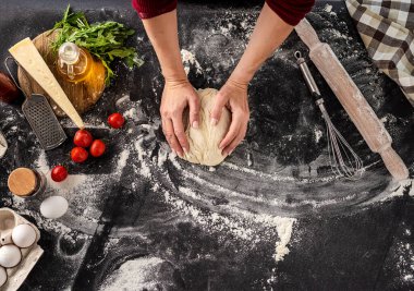 Pizza pişirmek için hamur yoğuran kadın.