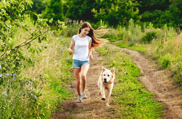 Chica corriendo con perro en la naturaleza — Foto de Stock