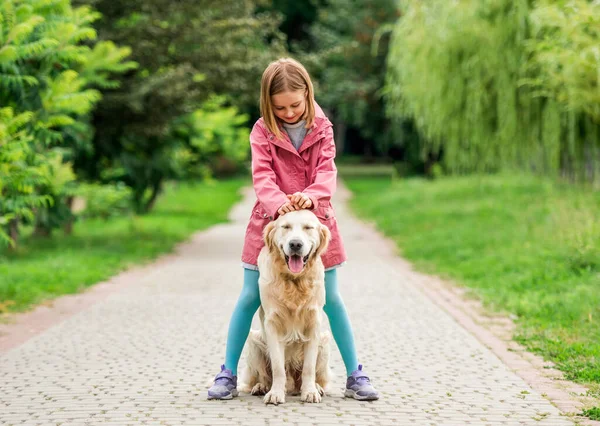 Menina de pé com o cão entre os pés — Fotografia de Stock