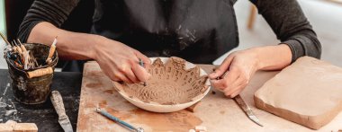 Desenler oluşturmak için çömlek aletleri kullanan kadın
