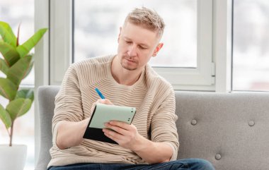 Not defteri olan serbest çalışan bir adam.