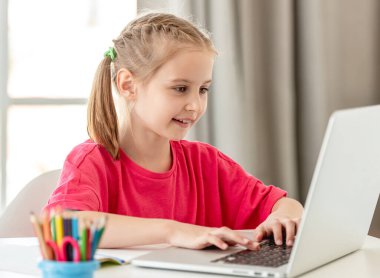 Küçük kız internette dizüstü bilgisayar kullanarak konuşuyor