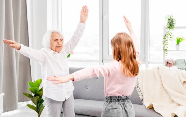 Büyükanne ve torun egzersiz yapıyor.
