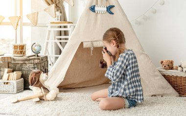 Güzel küçük kız pofuduk ayıcık fotoğrafı çekiyor.