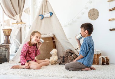 Çocuklar kendi yaptıkları telefonlarla oynuyorlar.