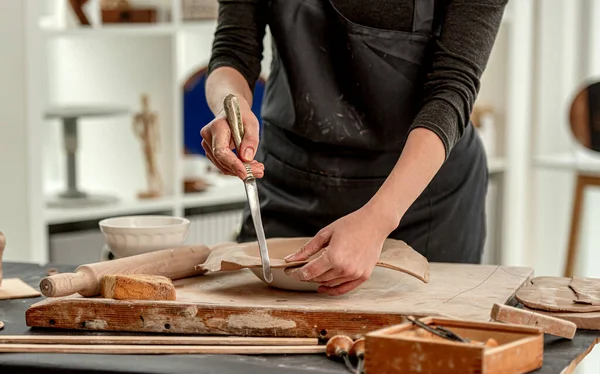 Женщина, использующая нож для формирования пластин — стоковое фото