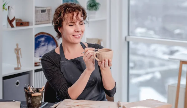 Glimlachende vrouw pottenbakker werken in de werkplaats — Stockfoto