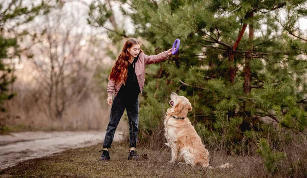Chica con perro golden retriever en el bosque — Foto de Stock