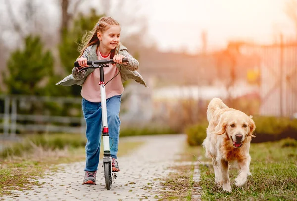 밖에 황금 리트리버 개를 데리고 있는 어린 소녀 — 스톡 사진
