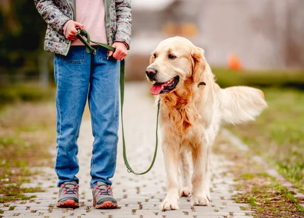 Liten flicka med golden retriever hund utanför — Stockfoto