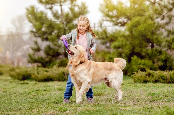 Gadis kecil dengan anjing golden retriever di luar — Stok Foto