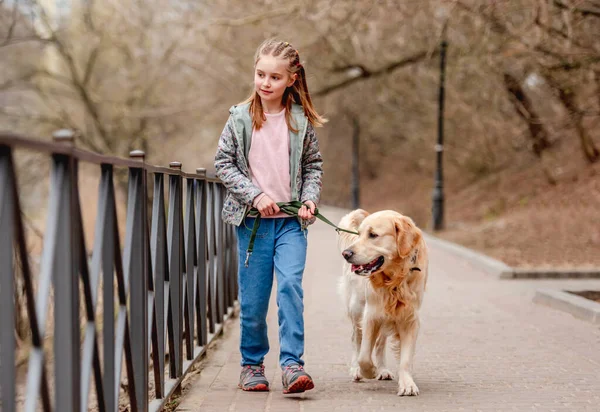 Klein meisje met golden retriever hond buiten — Stockfoto