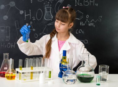 Kimya laboratuarındaki küçük zeki kız bir deney yapıyor.
