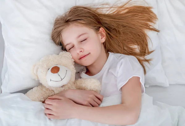 Chica en la cama con oso de peluche — Foto de Stock