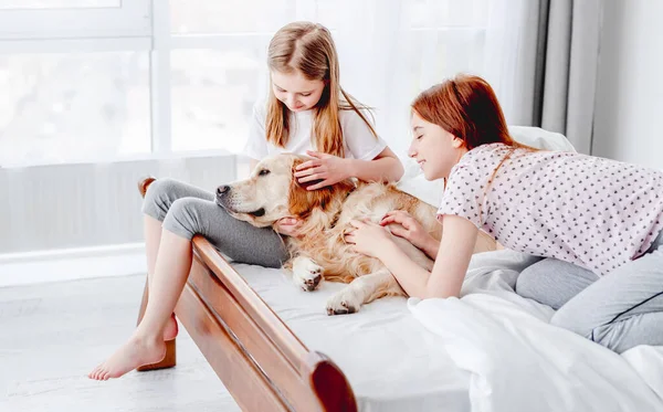 Mädchen mit Golden Retriever Hund im Bett — Stockfoto