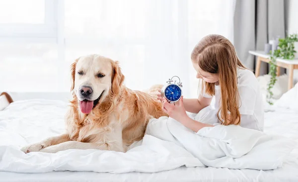 Chica con perro golden retriever en la cama — Foto de Stock