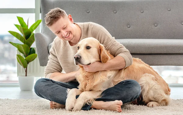 Hombre sentado con perro golden retriever — Foto de Stock