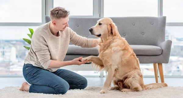 Homem sentado com cão golden retriever — Fotografia de Stock