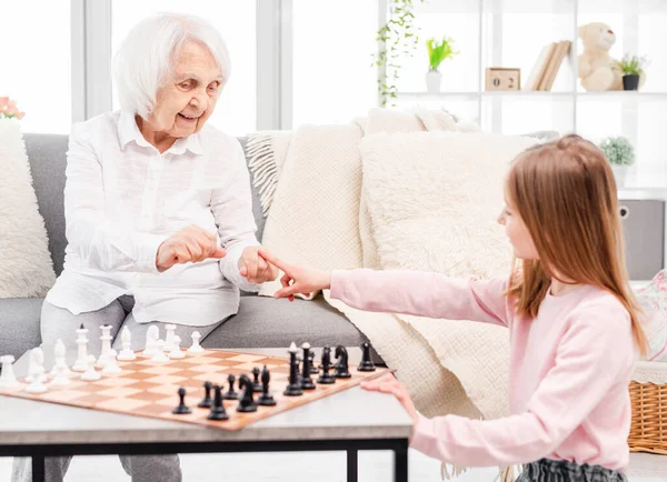 Flicka spelar schack med mormor — Stockfoto