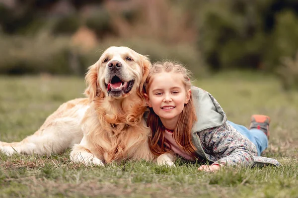 Klein meisje met golden retriever hond buiten — Stockfoto