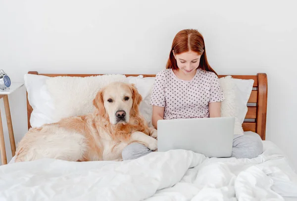 Girl with laptop and golden retriever dog — Stock Photo, Image