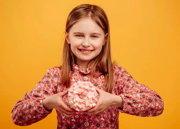 Menina com donut isolado no fundo amarelo — Fotografia de Stock