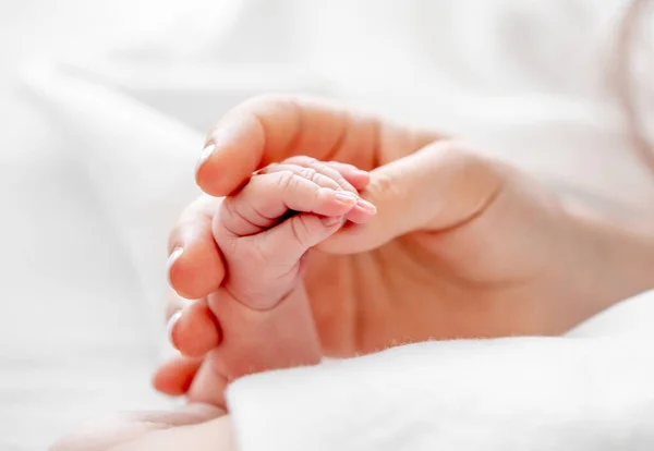 Madre sosteniendo la mano del bebé recién nacido — Foto de Stock