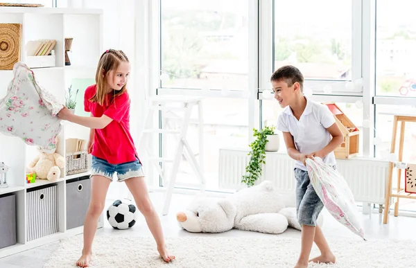 Riendo niños divirtiéndose mientras almohada lucha —  Fotos de Stock