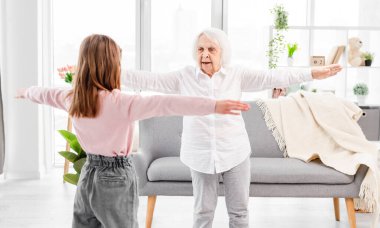 Büyükanne ve torun egzersiz yapıyor.