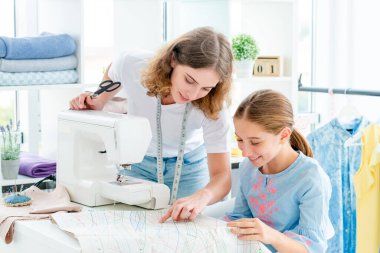 Terzi öğrenciye ders veriyor.