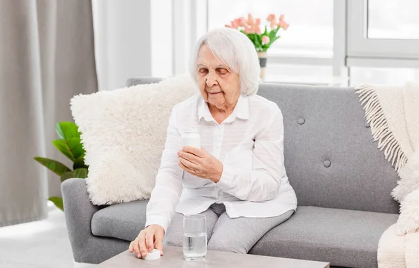 Mujer anciana tomando pastillas — Foto de Stock