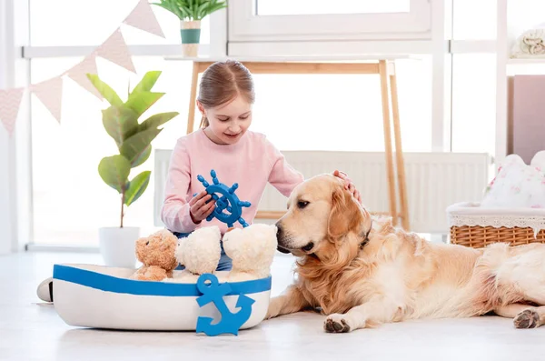 Menina jogar com navio do mar com cão golden retriever — Fotografia de Stock