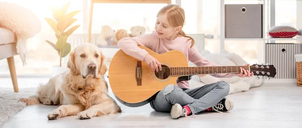 Liten flicka med gitarr och golden retriever hund — Stockfoto