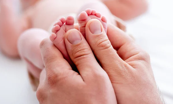 Madre che tiene i piedi del bambino appena nato — Foto Stock