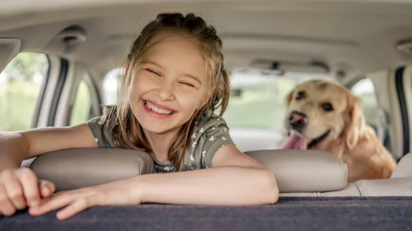 Arabasında golden retriever köpeği olan genç bir kız. — Stok fotoğraf