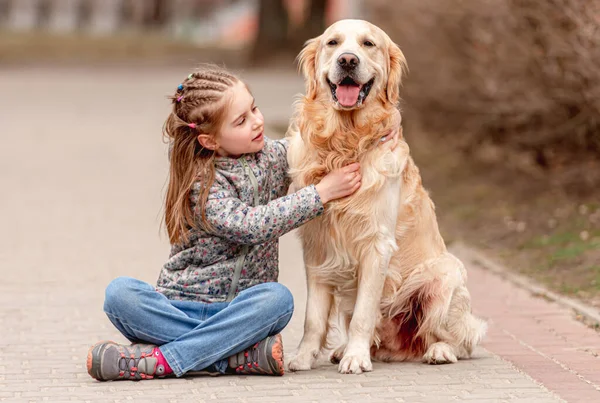 Preteen flicka med golden retriever hund — Stockfoto