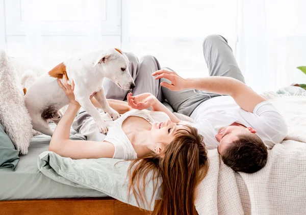 Paar in het bed met hond — Stockfoto