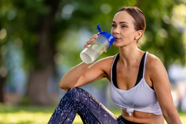 Flicka med vatten under yogan — Stockfoto