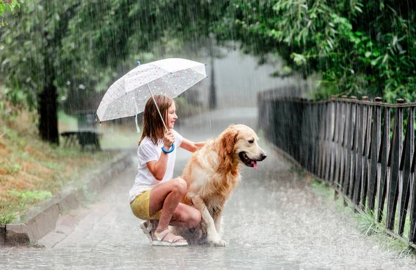 Menina com cão golden retriever em dia chuvoso — Fotografia de Stock